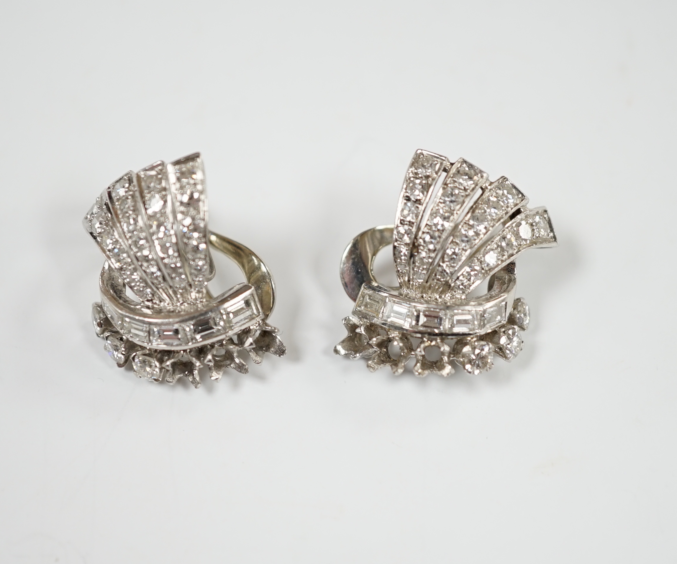 A pair of white metal, round and baguette cut diamond cluster set fan shaped earrings, 20mm, gross weight 10.7 grams (three stones missing from each).